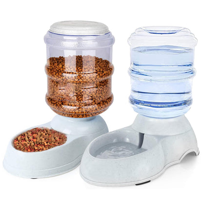 Automatic dog feeder and water dispenser set, featuring a clear food container with brown kibble and a clear water reservoir, both on a white base.