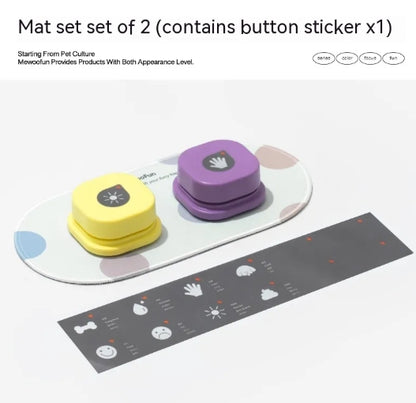 Two pet communication buttons in yellow and purple, placed on a curved mat, with a gray sticker guide nearby.